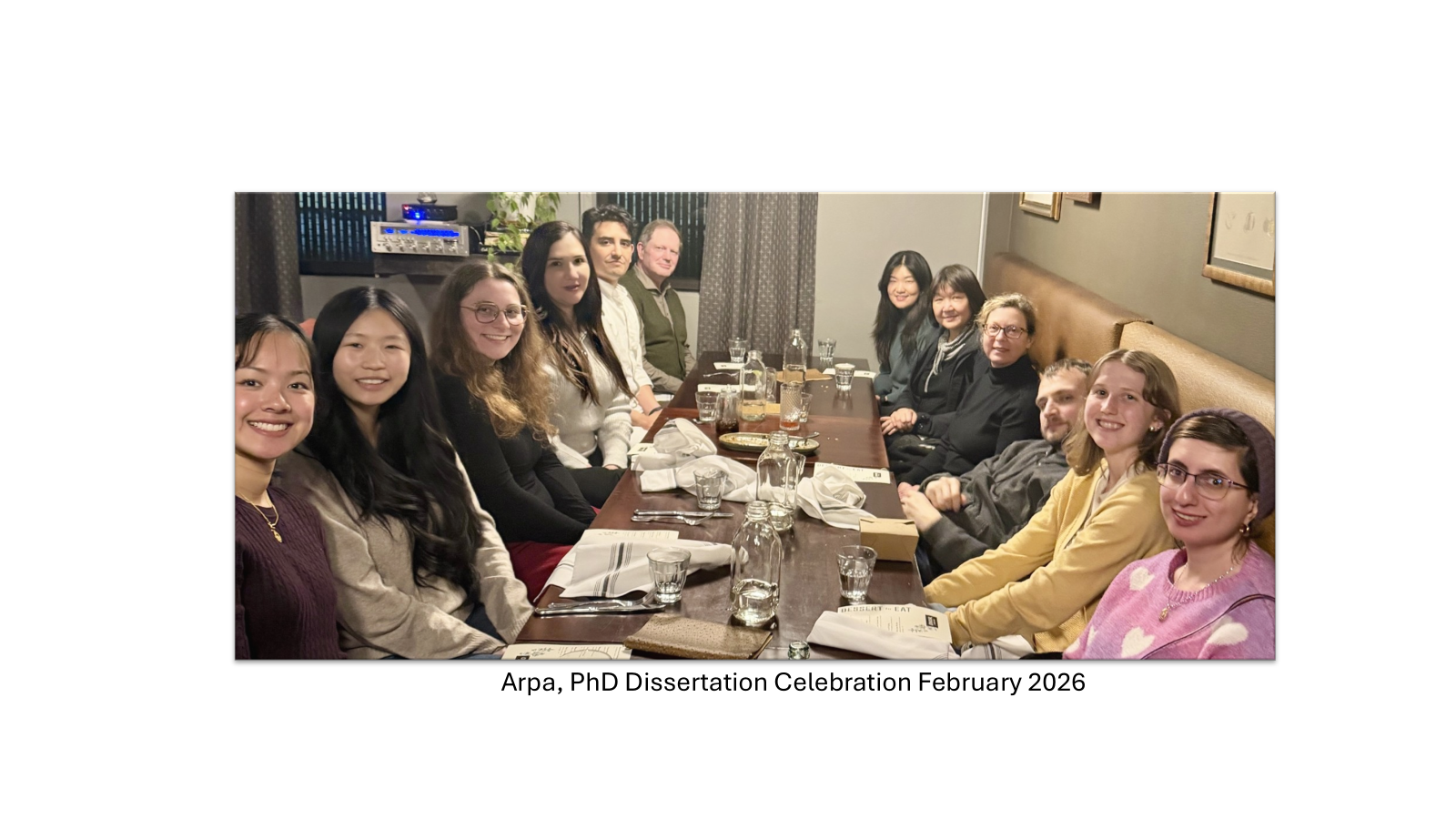 Lab group seated around a long restaurant table, celebrating together